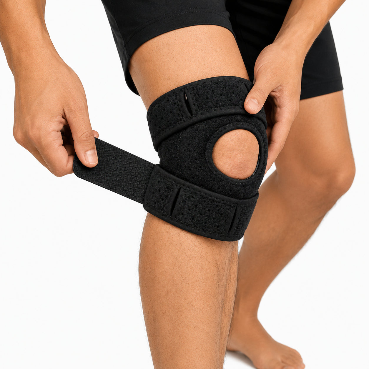 Person som justerar remmen på ett knästöd med patellaöppning för individuell passform.