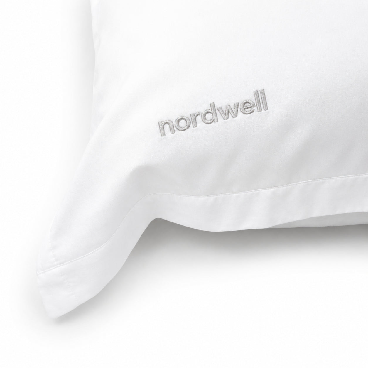 Närbild på mjuk polyester-satin och broderad logotyp