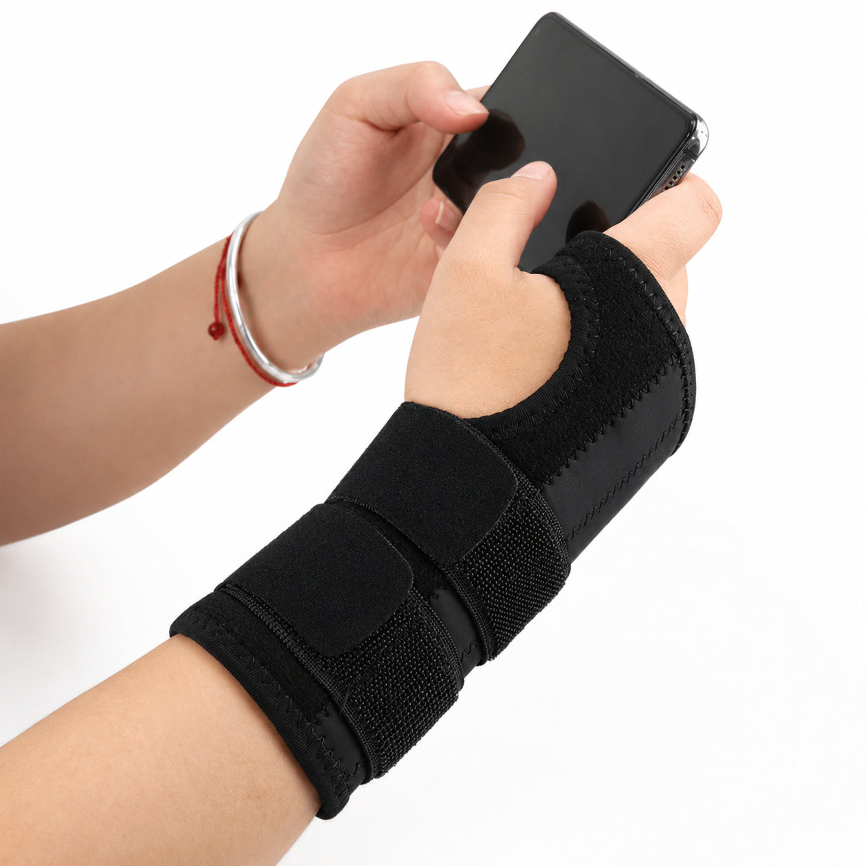 Person använder stabilt handledsbandage vid mobilanvändning.