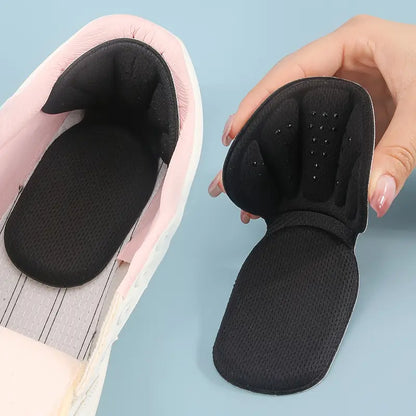 T-formade hälkuddar i svart – visas i sneakers och hålls i hand för att visa flexibel design.