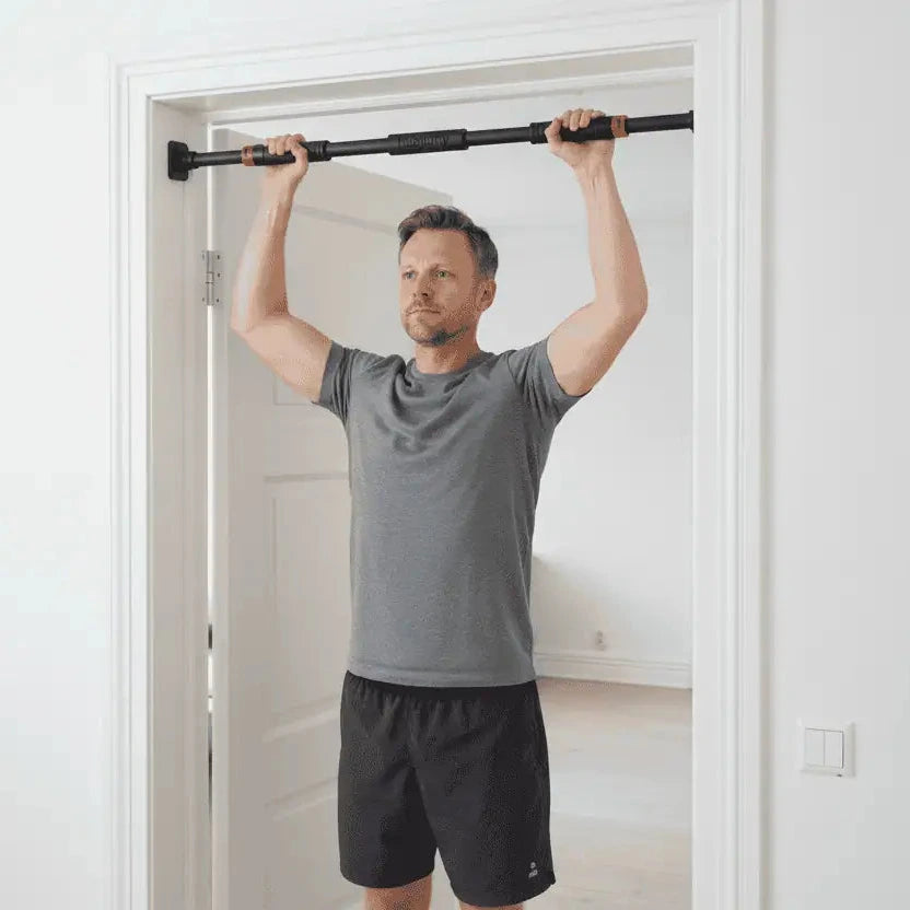 Träningsstång som används för kroppsviktsträning i dörröppning